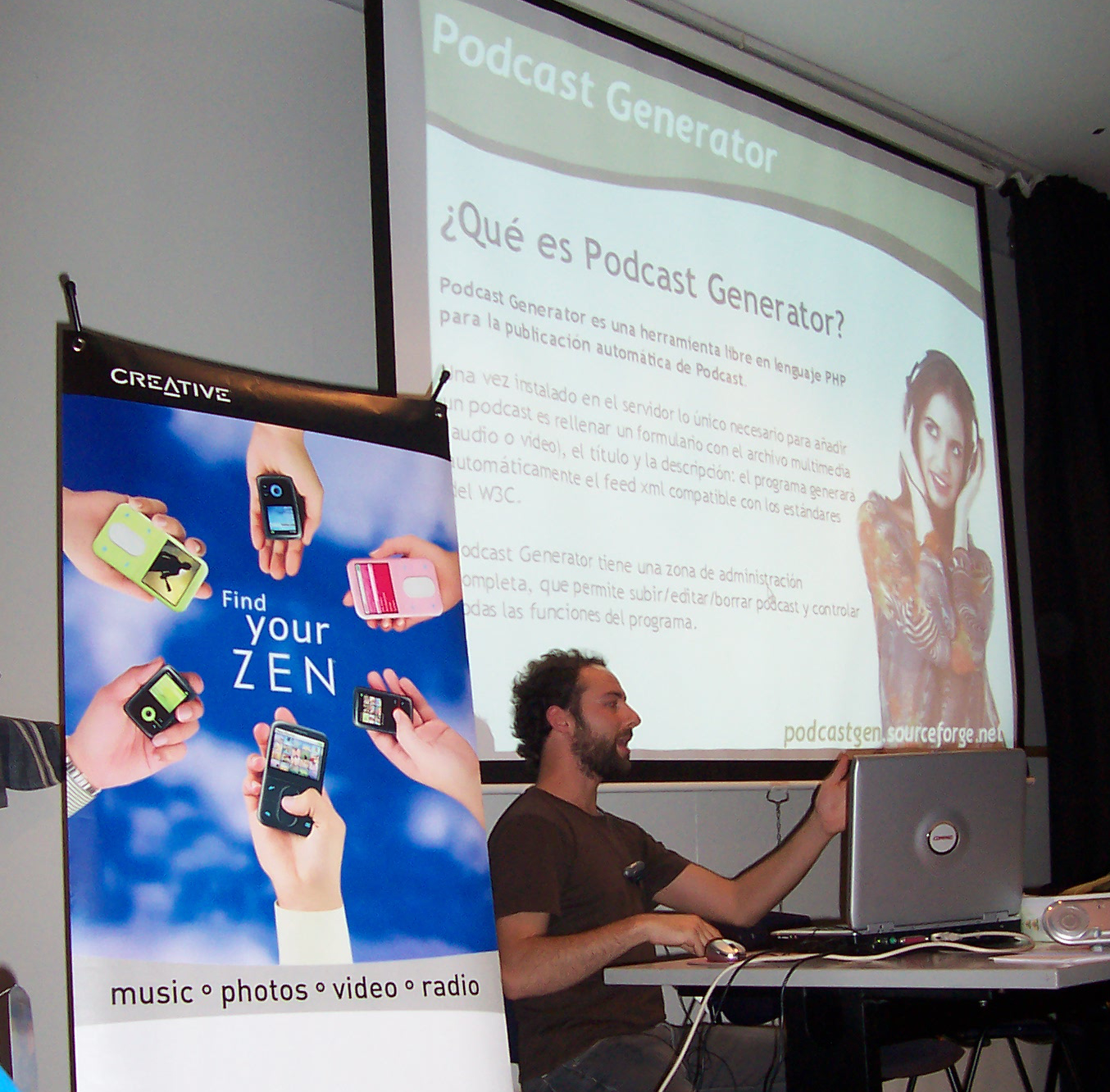 Alberto Betella presenting Podcast Generator at the II Jornadas de Podcasting in Barcelona, October 2006. Slide shows Que es Podcast Generator with the iconic girl-with-headphones illustration