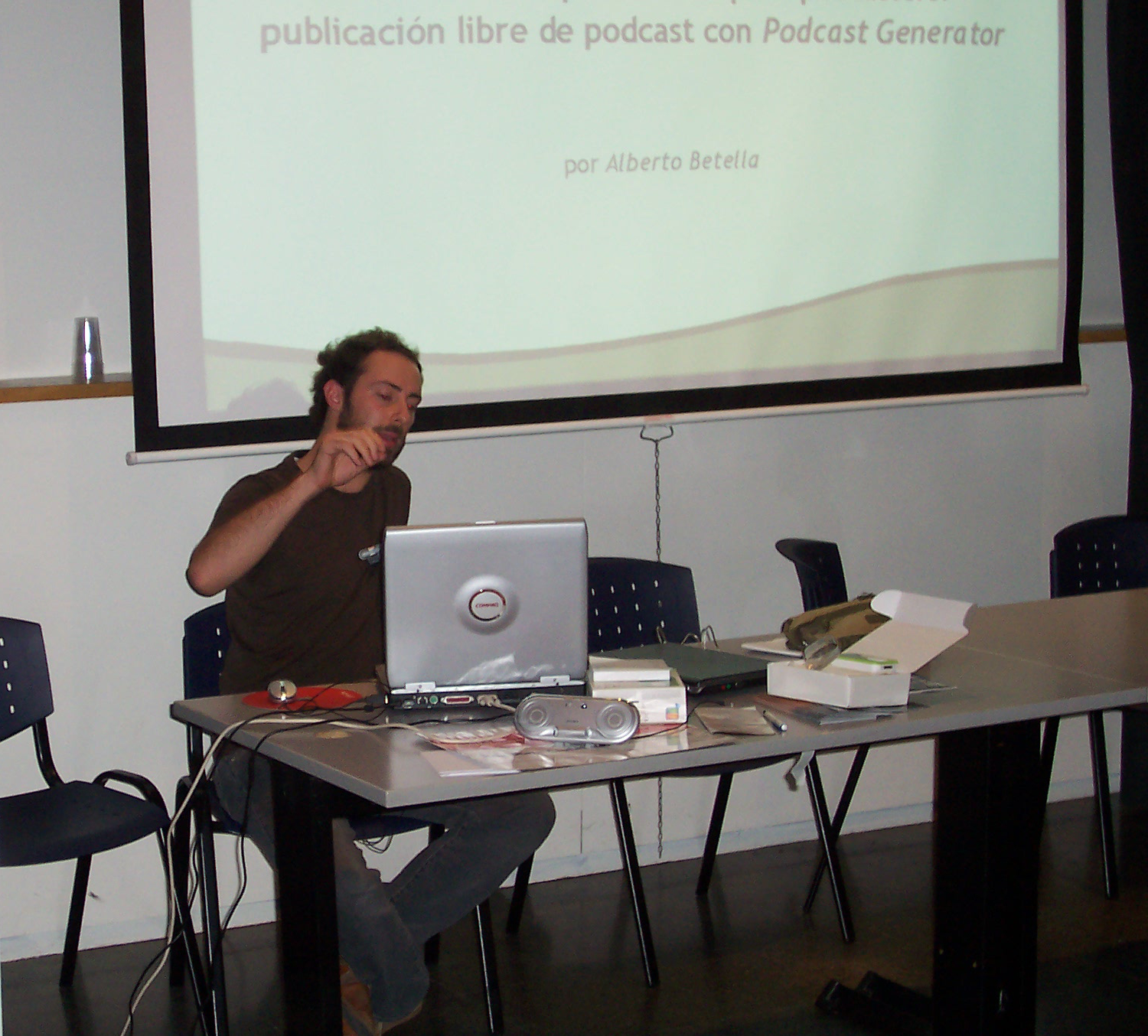 Alberto Betella behind his laptop at the Jornadas de Podcasting, Barcelona, with the title slide projected